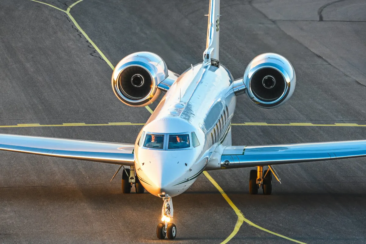 Business jet taxiing toward the camera on a ramp